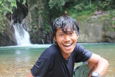 Portrait of smiling man in waterfall