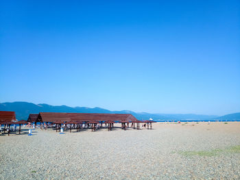 Scenic view of beach against clear blue sky