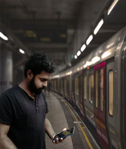 Full length of man standing on train at railroad station