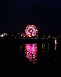 Illuminated ferris wheel at night