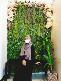 Woman sitting on potted plant