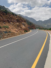 Road by mountain against sky