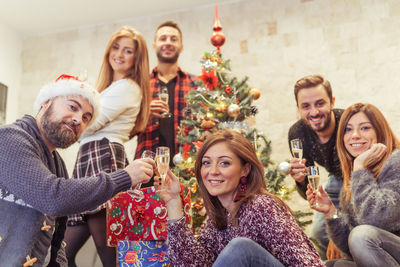 Portrait of cheerful family by christmas tree at home