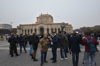 Group of people walking in front of historical building