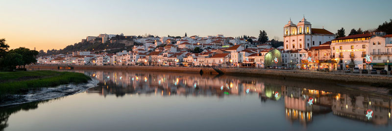 Panorama view of alcacer do sal cityscape from the other side of the sado river at sunset