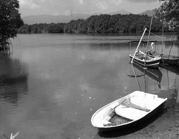 Boats moored in lake against sky