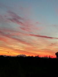 Silhouette landscape against sky at sunset