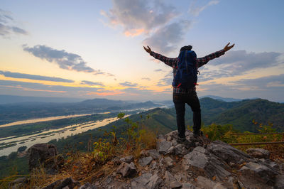 Hiker standing on the cliff watching the view of mekong river in morning