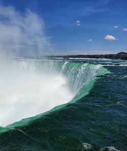 Scenic view of waterfall against sky