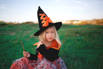 Woman wearing hat sitting on field