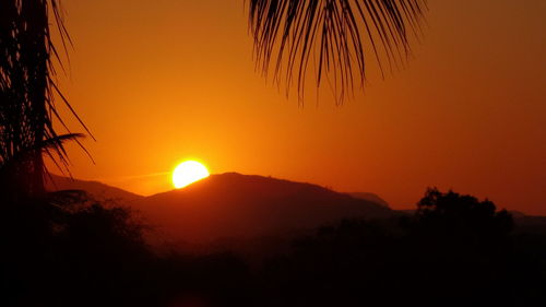 Scenic view of silhouette mountains against romantic sky at sunset