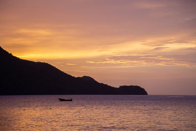 Scenic view of boat in sea against sky during sunset