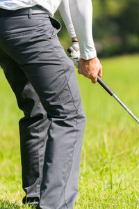 Low section of man playing golf on course