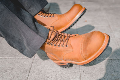 Low section of person wearing shoes on tiled floor