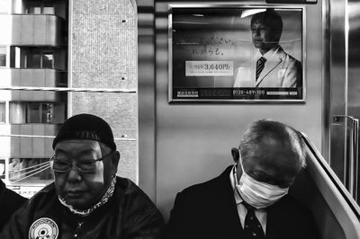 Portrait of man standing with reflection on glass