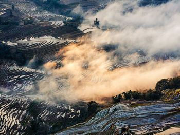 Aerial view of land and mountains against sky