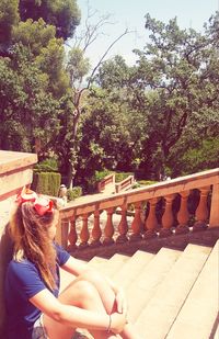 Woman on railing against trees