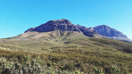 Scenic view of mountains against clear blue sky