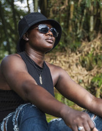 African woman sitting with hat and sunglasses in aburi jungle ghana