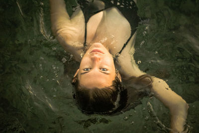 Portrait of man lying in swimming pool