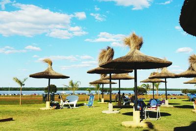 Lounge chairs on beach against sky