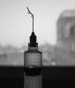 Close-up of glass bottle against sky