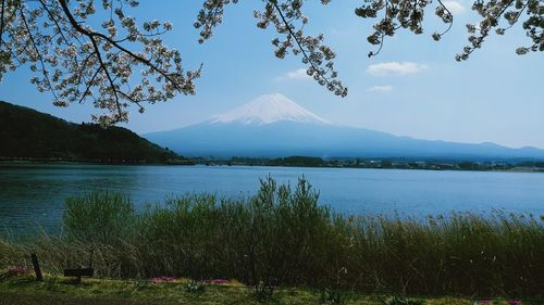 Scenic view of lake by mountains against sky