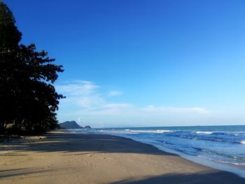 Scenic view of beach against blue sky