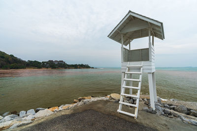 Lifeguard hut on beach against sky