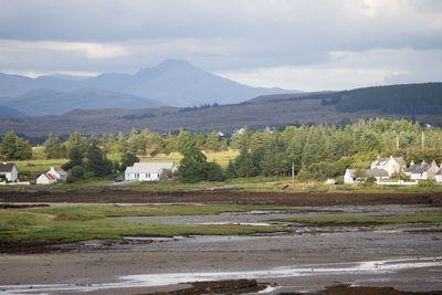 Scenic view of field and mountains against sky