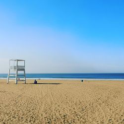 Scenic view of beach against clear blue sky