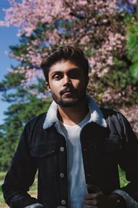 Portrait of young man standing against plants