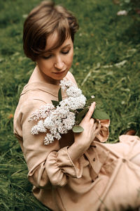 Close-up of girl holding plant on field