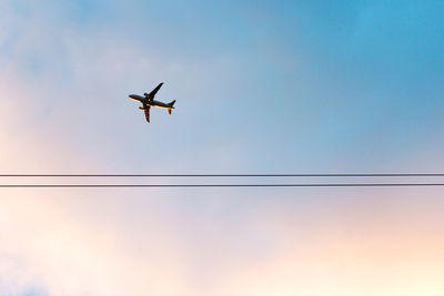 Low angle view of airplane flying against sky