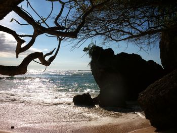 Rock formation on beach against sky