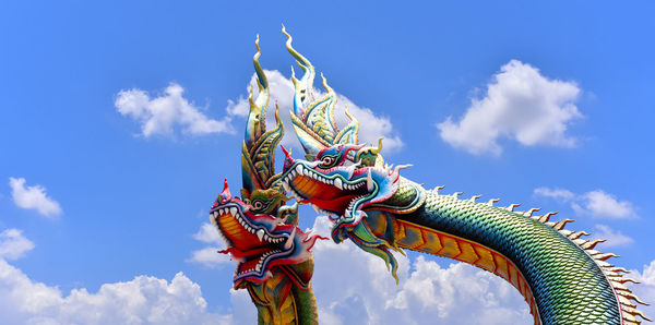  low angle twin stucco painted as a large serpent at pra kai keaw wang nakin,  udon thani, thailand.