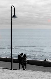 Man standing by sea against sky