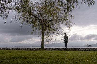 Man standing on field against sky