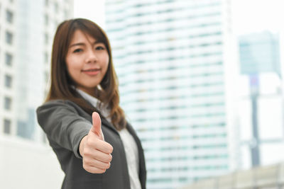 Young businesswoman gesturing while standing in city