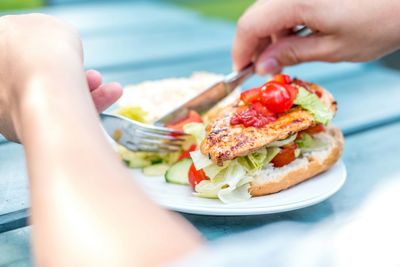 Close-up of man eating sandwich with salad