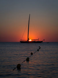 Sailboat in sea at sunset