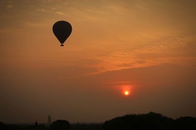 Silhouette hot air balloons against sky during sunset