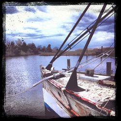 Boats in sea against cloudy sky