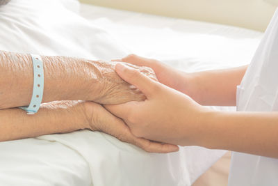 Midsection of couple lying on bed