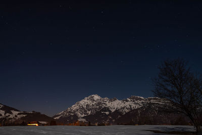 Scenic view of snowcapped mountains against sky at night