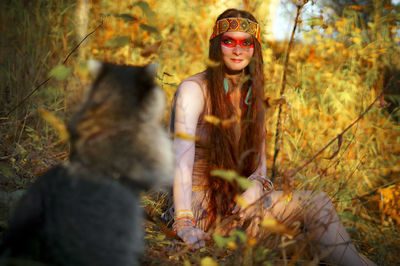 Young woman sitting in park during autumn