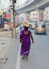 Rear view of woman walking on street in city