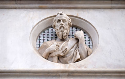 Saint, relief on the facade of basilica of santa croce - famous franciscan church in florence, italy