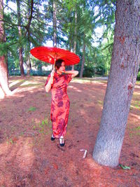 Full length of woman standing on tree trunk