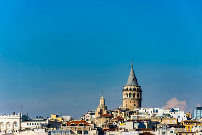 View of buildings in city against blue sky